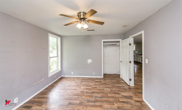 unfurnished bedroom featuring hardwood / wood-style floors, ceiling fan, and a closet