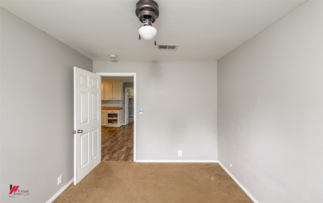 spare room featuring dark carpet