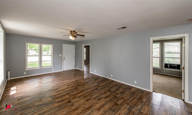 unfurnished room featuring dark wood-type flooring, ceiling fan, and a healthy amount of sunlight