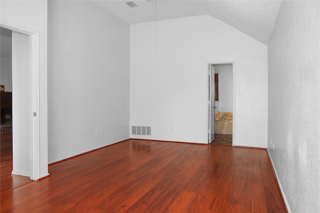 empty room featuring lofted ceiling and wood-type flooring