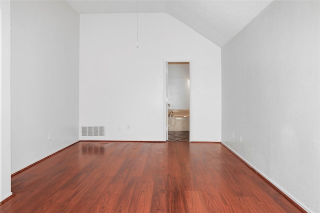 empty room featuring wood-type flooring and vaulted ceiling