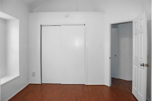 unfurnished bedroom with a closet and dark hardwood / wood-style floors