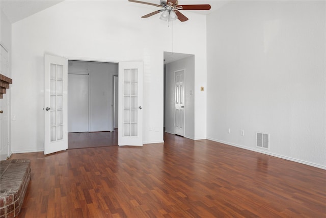 unfurnished living room with high vaulted ceiling, dark wood-type flooring, ceiling fan, and french doors