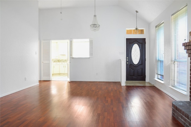 entryway featuring dark wood-type flooring and high vaulted ceiling