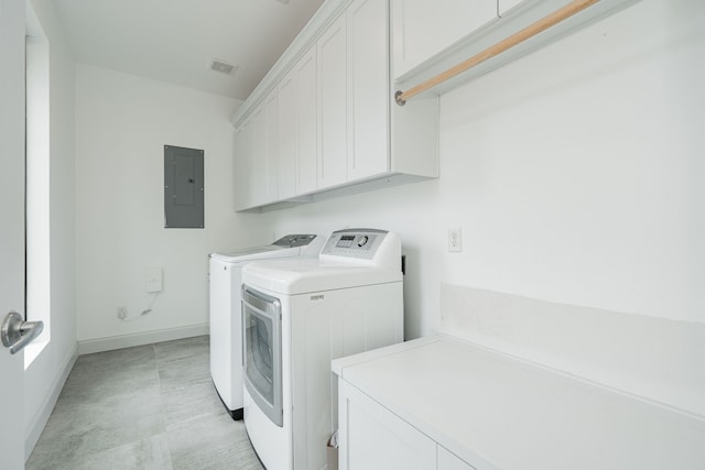 clothes washing area featuring cabinets, electric panel, and washer and clothes dryer