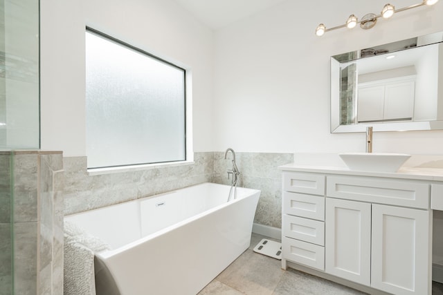 bathroom featuring vanity, tile patterned floors, a tub, and tile walls