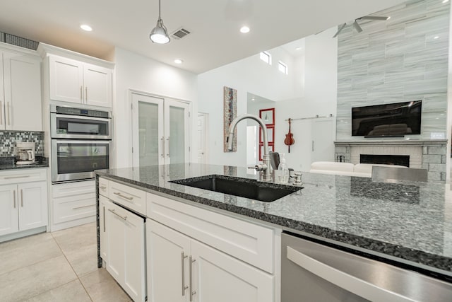 kitchen featuring white cabinetry, sink, dark stone counters, and appliances with stainless steel finishes