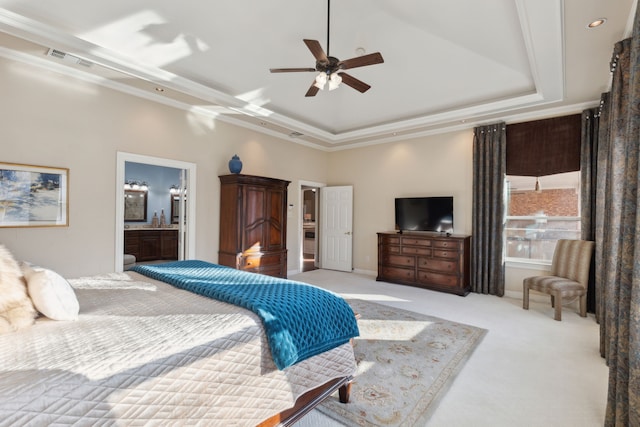 bedroom with ensuite bathroom, crown molding, light carpet, a tray ceiling, and ceiling fan