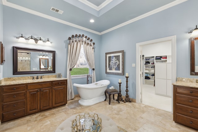 bathroom featuring a bathing tub, ornamental molding, and vanity