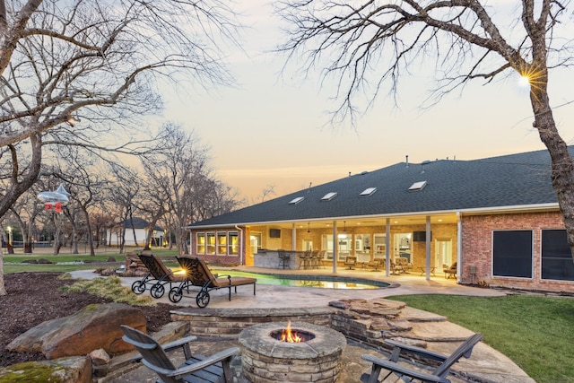 pool at dusk featuring a patio and a fire pit