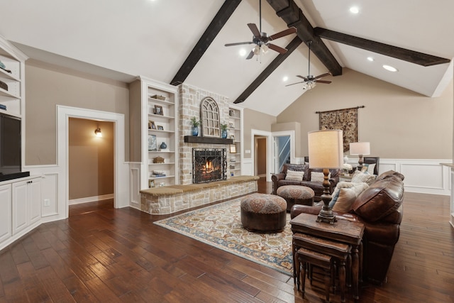 living room featuring beam ceiling, a stone fireplace, and dark hardwood / wood-style flooring