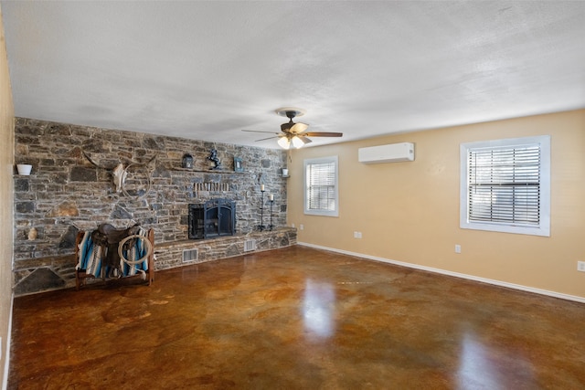 unfurnished living room with ceiling fan, a textured ceiling, a fireplace, and a wall mounted AC