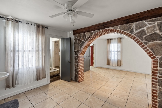 tiled spare room with brick wall and ceiling fan