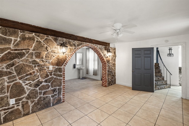 unfurnished living room featuring light tile patterned flooring and ceiling fan