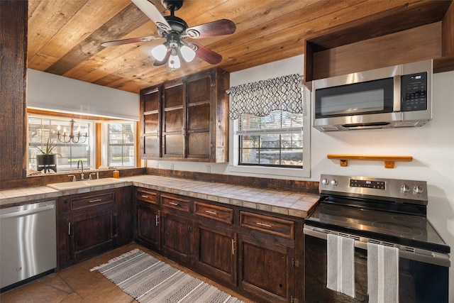 kitchen featuring appliances with stainless steel finishes, tile countertops, and dark brown cabinetry