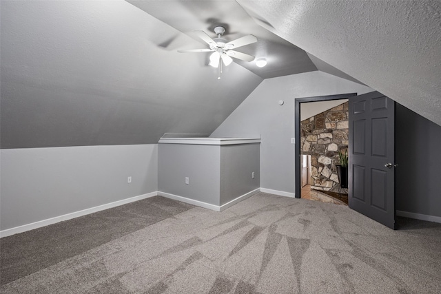 additional living space with lofted ceiling, carpet floors, and a textured ceiling