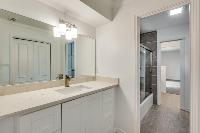 bathroom with vanity and shower / bath combination with glass door