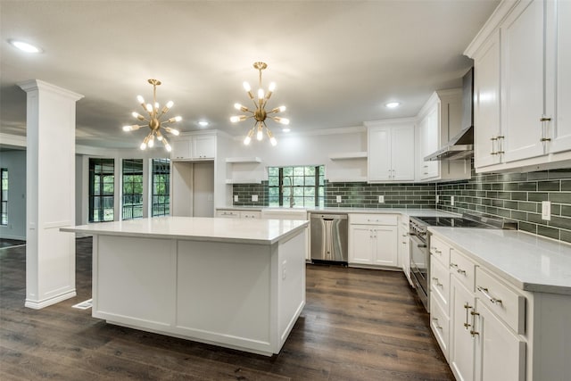 kitchen featuring white cabinetry, tasteful backsplash, appliances with stainless steel finishes, a kitchen island, and pendant lighting