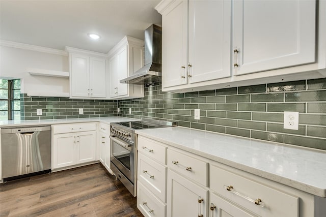 kitchen with backsplash, stainless steel appliances, light stone counters, white cabinets, and wall chimney exhaust hood