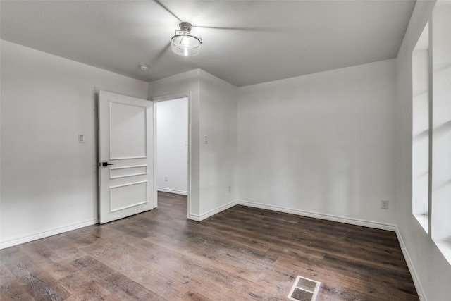 empty room with dark hardwood / wood-style flooring