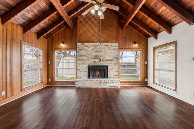 unfurnished living room featuring a fireplace, dark hardwood / wood-style flooring, and wood walls