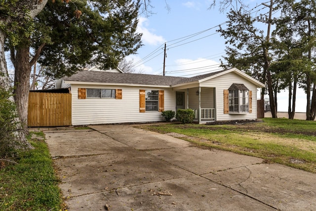 ranch-style home featuring a front lawn and covered porch