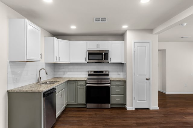 kitchen with stainless steel appliances, white cabinetry, sink, and dark hardwood / wood-style floors