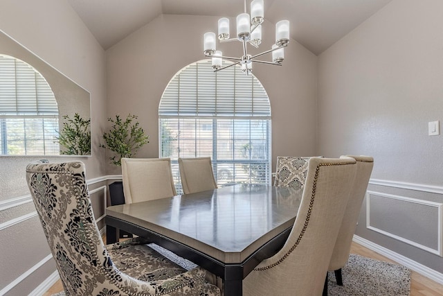 dining space featuring hardwood / wood-style floors, vaulted ceiling, a chandelier, and plenty of natural light