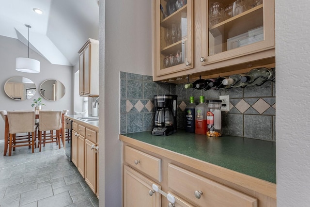 kitchen with tasteful backsplash, lofted ceiling, sink, hanging light fixtures, and light brown cabinets