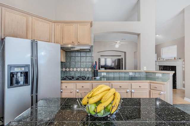 kitchen with stainless steel refrigerator with ice dispenser, black gas stovetop, light brown cabinetry, and decorative backsplash