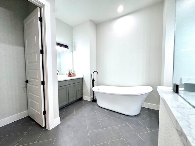 bathroom featuring vanity, tile patterned flooring, and a bath