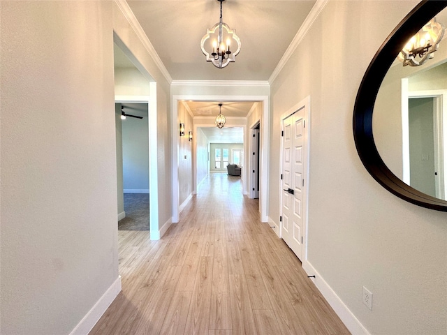 hallway featuring light hardwood / wood-style floors, a chandelier, and ornamental molding