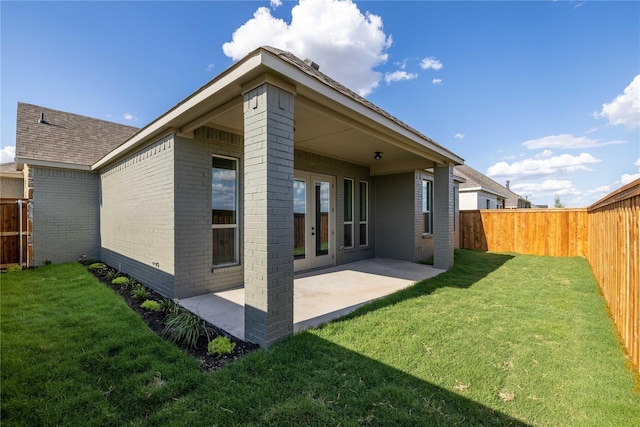 rear view of property with a lawn and a patio area