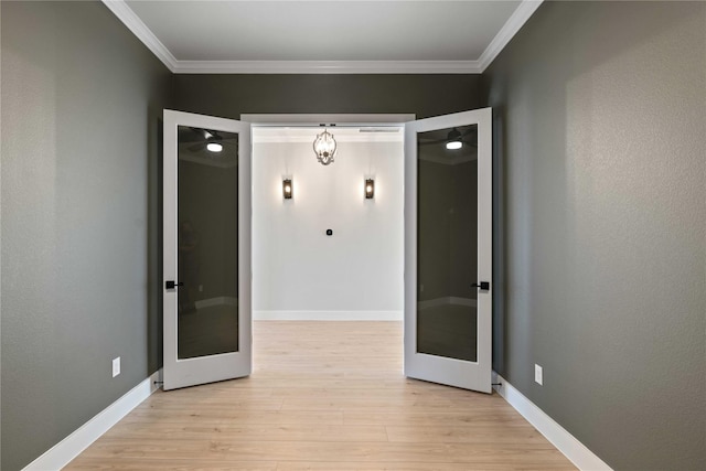 unfurnished room with light wood-type flooring, french doors, and ornamental molding