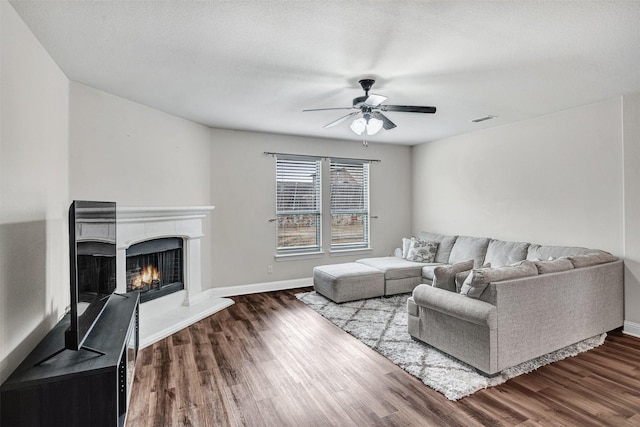 living room with a textured ceiling, dark hardwood / wood-style floors, and ceiling fan