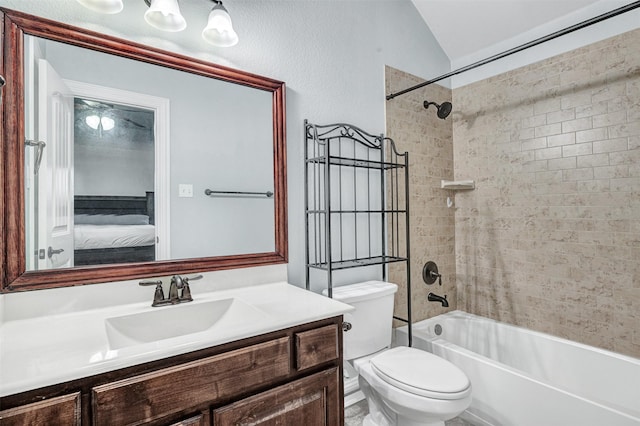 full bathroom with vanity, tiled shower / bath, toilet, and lofted ceiling