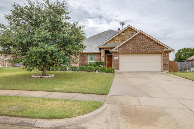 view of front of house featuring a garage, brick siding, fence, and a front yard