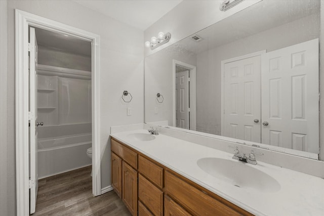 full bathroom featuring vanity, wood-type flooring, shower / bathing tub combination, and toilet