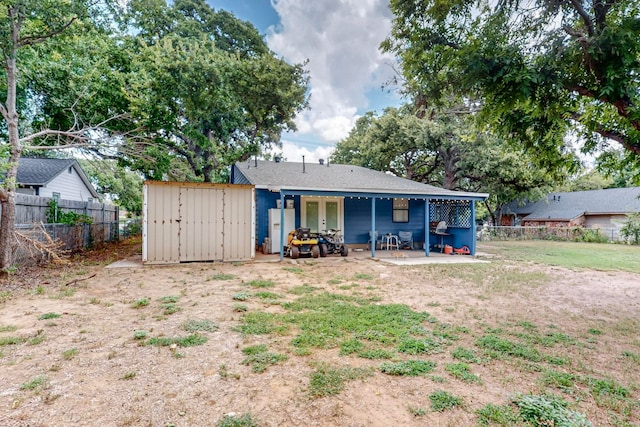 rear view of house featuring a storage shed, a lawn, and a patio