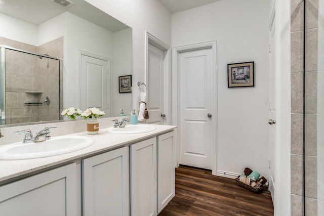 bathroom with vanity, wood-type flooring, and a shower with door