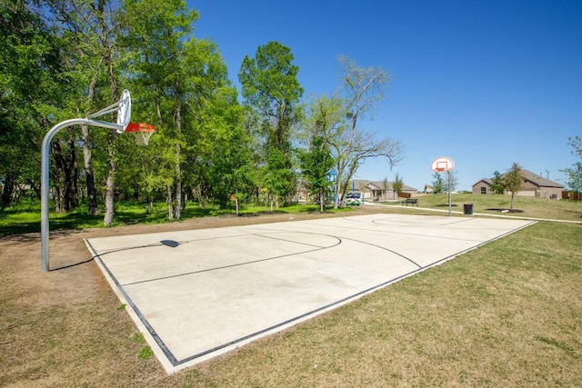 view of sport court with a lawn