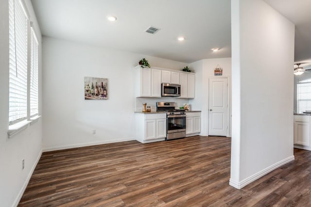 kitchen with white cabinetry, stainless steel appliances, dark hardwood / wood-style floors, and a healthy amount of sunlight