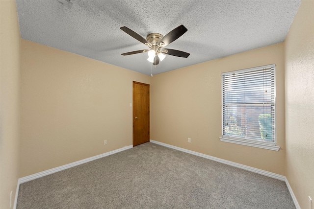 carpeted empty room featuring ceiling fan and a textured ceiling