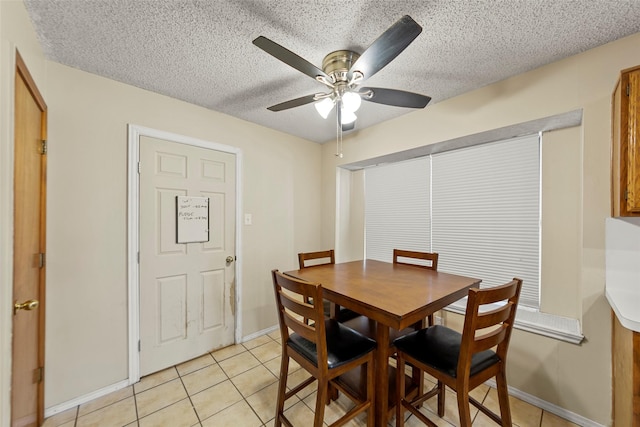 tiled dining space with ceiling fan and a textured ceiling