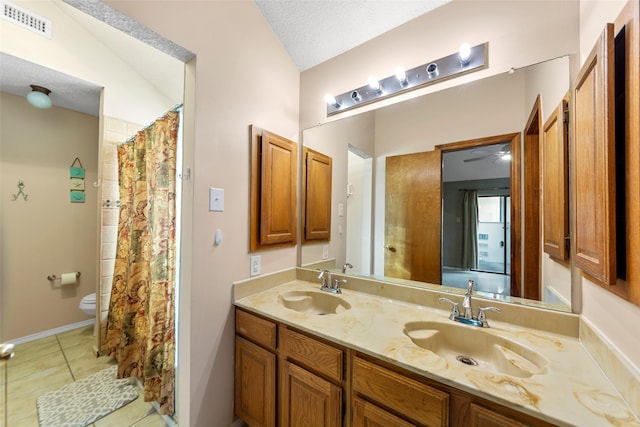 bathroom featuring vanity, tile patterned flooring, a textured ceiling, and toilet