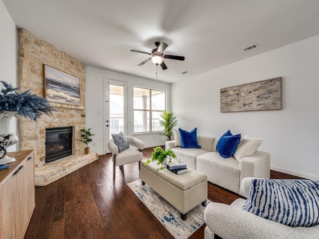 living room featuring ceiling fan, a fireplace, and dark hardwood / wood-style flooring