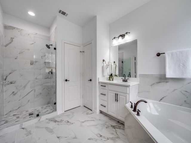 bathroom featuring vanity and independent shower and bath