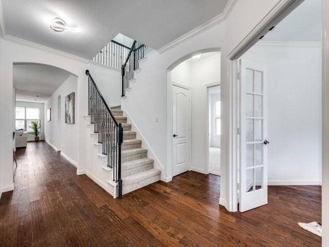 entrance foyer with ornamental molding and dark wood-type flooring