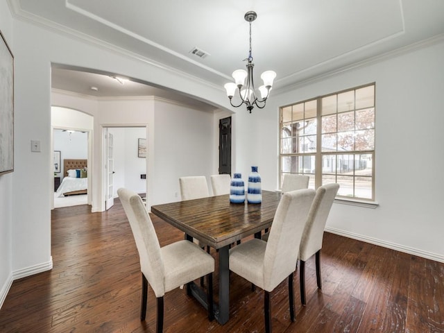 dining room featuring an inviting chandelier, dark wood-type flooring, and ornamental molding