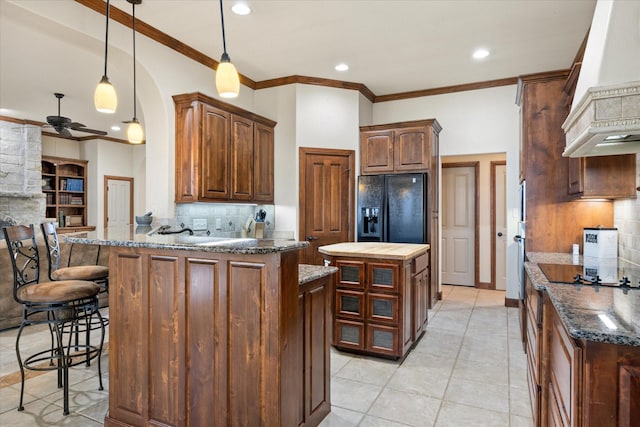 kitchen featuring a center island, decorative light fixtures, decorative backsplash, and black appliances